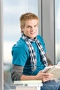 Young man with ear buds and books Royalty Free Stock Photo