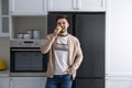 Man eating apple near refrigerator in kitchen Royalty Free Stock Photo