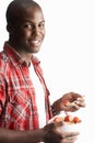 Young Man Eating Bowl Of Cereal In Studio