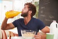 Young Man Eating Breakfast And Drinking Orange Juice Royalty Free Stock Photo