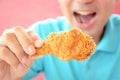 Young man eating deep fried chicken leg or drumstick Royalty Free Stock Photo