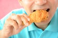 Young man eating deep fried chicken leg or drumstick Royalty Free Stock Photo