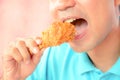 Young man eating deep fried chicken leg or drumstick Royalty Free Stock Photo