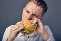 Young man eating a fresh burger