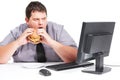 Stop showing me healthy things. A young man eating his lunch at his desk at work while staring with mouth agape at his Royalty Free Stock Photo