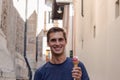 Young man eating ice cream in an alley