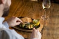 Young man eating salmon fillet with gratinated potatoes, leek and spinach Royalty Free Stock Photo