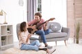 Young man with electric guitar and his girlfriend composing song Royalty Free Stock Photo