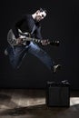 Young man with electric guitar jumping on stage Royalty Free Stock Photo