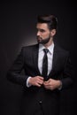 Young man elegant suit buttoning, looking sideways Royalty Free Stock Photo
