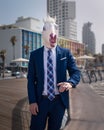 Young man in elegant suit stands on the city waterfront