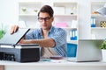 The young man employee working at copying machine in the office Royalty Free Stock Photo