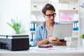 The young man employee working at copying machine in the office Royalty Free Stock Photo