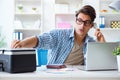 The young man employee working at copying machine in the office Royalty Free Stock Photo