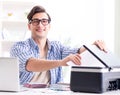 Young man employee working at copying machine in the office Royalty Free Stock Photo