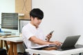 Man employee working with laptop computer and using mobile phone in home office. Royalty Free Stock Photo