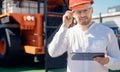 Young man engineer in helmet with tablet computer in hands on background of truck for coal mining ore Royalty Free Stock Photo