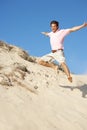 Young Man Enjoying Beach Holiday Running Down Dune Royalty Free Stock Photo