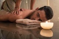 Young man enjoying the healing benefits of traditional Thai mass Royalty Free Stock Photo