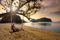 Young man enjoys sunset on a swing at a beach in Thailand Royalty Free Stock Photo