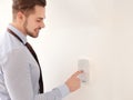 Young man entering code on security alarm system, indoors Royalty Free Stock Photo