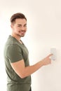 Young man entering code on security alarm system, indoors Royalty Free Stock Photo