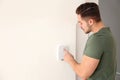 Young man entering code on security alarm system, indoors Royalty Free Stock Photo