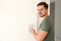 Young man entering code on security alarm system, indoors Royalty Free Stock Photo