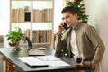 Man entrepreneur working with laptop computer and talking on mobile phone. Royalty Free Stock Photo