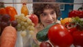 A young man examines a refrigerator filled with healthy products: vegetables, fruits, berries. Portrait of a satisfied Royalty Free Stock Photo