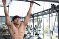 young man execute exercise with machine in fitness center. male athlete training in gym. sporty guy working out in health club. Royalty Free Stock Photo