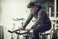 Young man exercising in gym: spinning on stationary bike