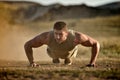 Young man exercising outdoor on dusty field Royalty Free Stock Photo