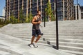 Young man exercising outside. Guy jogging or slow running besides steps. Training or having workout outside. Exercsing Royalty Free Stock Photo