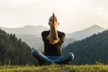 Young man exercising yoga asanas in mountains at sunset