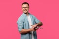 young man in eyeglasses holding revolver and smiling at camera isolated