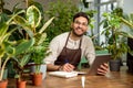 Young man in eyeglasses working in the flower shop and looking busy Royalty Free Stock Photo