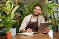 Young man in eyeglasses working in the flower shop and looking busy Royalty Free Stock Photo