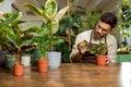 Young man in eyeglasses working in the flower shop and looking busy Royalty Free Stock Photo