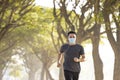 Young man in face mask and running in the park Royalty Free Stock Photo
