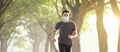 Young man in face mask and running in the park Royalty Free Stock Photo