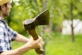 Young man in the farm garden working with axe and cutting the fruit treeon summer day a Royalty Free Stock Photo