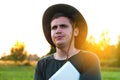 Young man farmer in cowboy hat at agricultural field on sunset holding tablet and speaking. Portrait of happy man on Royalty Free Stock Photo