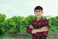 Man farmer smiling and standing in custard apple trees orchard background Royalty Free Stock Photo