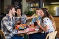 Young man feeding burger to friend in restaurant Royalty Free Stock Photo