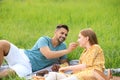 Young man feeding his girlfriend with grape on blanket outdoors Royalty Free Stock Photo