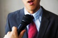 Young man feeling awkward getting asked by a journalist on isolated white background