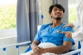 Young man with fever lying in bed with her shaking in hospital background Sick male patient lying in bed with doctor taking care Royalty Free Stock Photo