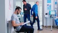 Young man filling documents in hospital waiting area Royalty Free Stock Photo