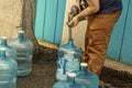 Young man filling five gallon jugs for use in dry cabin - with no running water- in Alaska USA Royalty Free Stock Photo